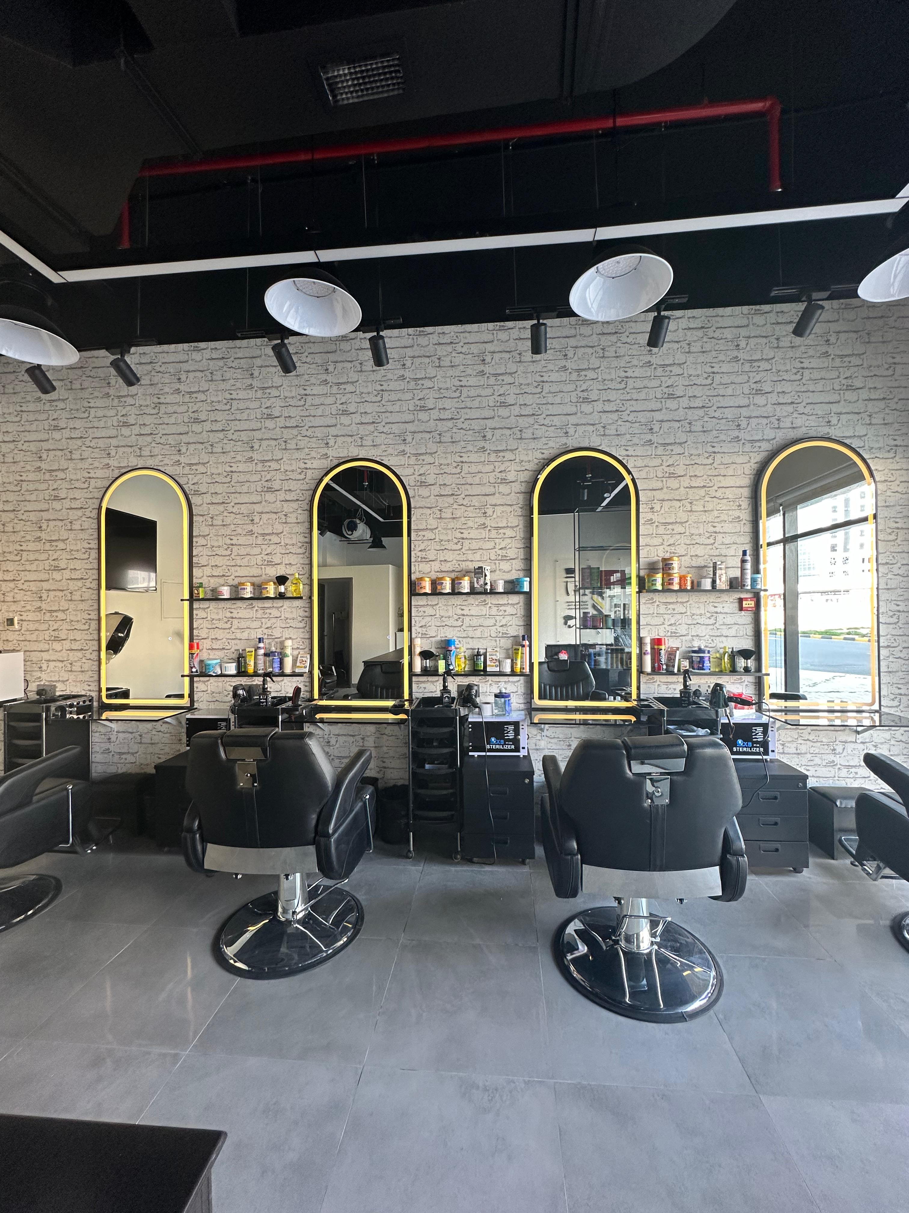Three barber chairs with arched mirrors and brass trim